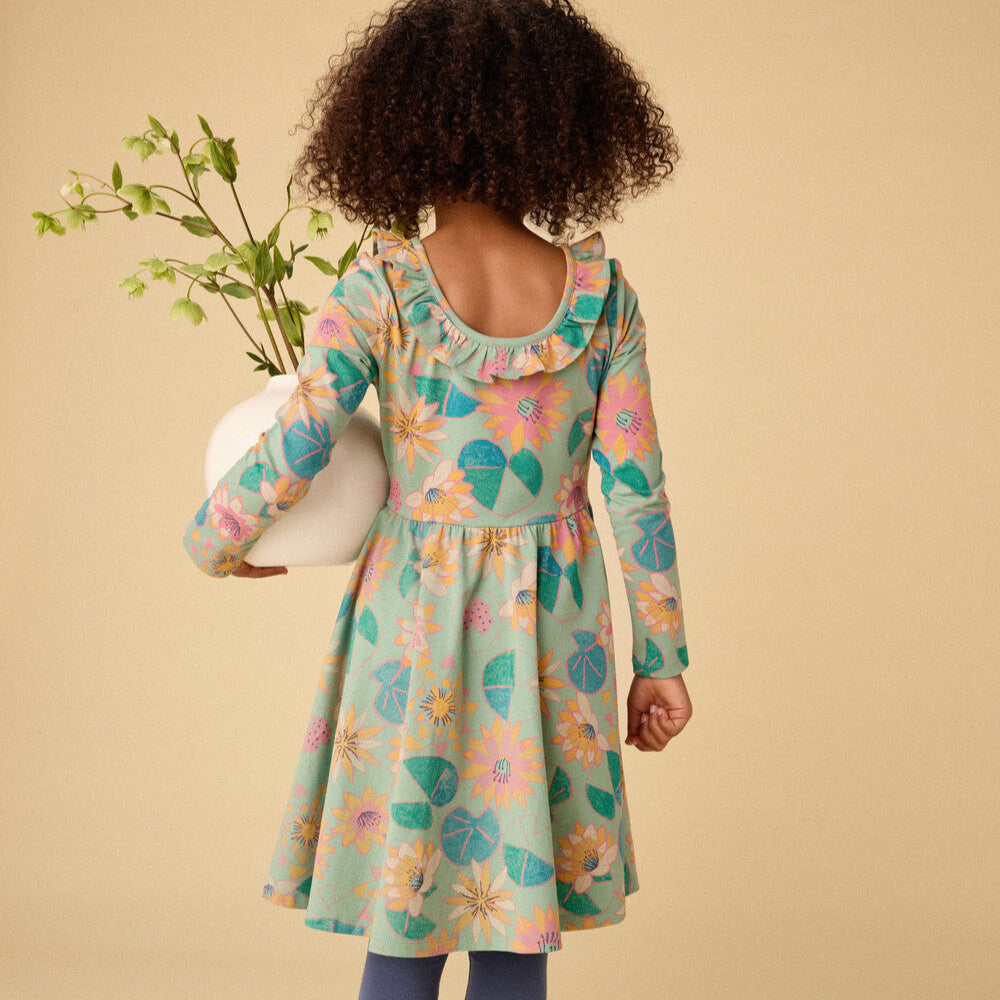 Child wearing a floral dress on a beige background