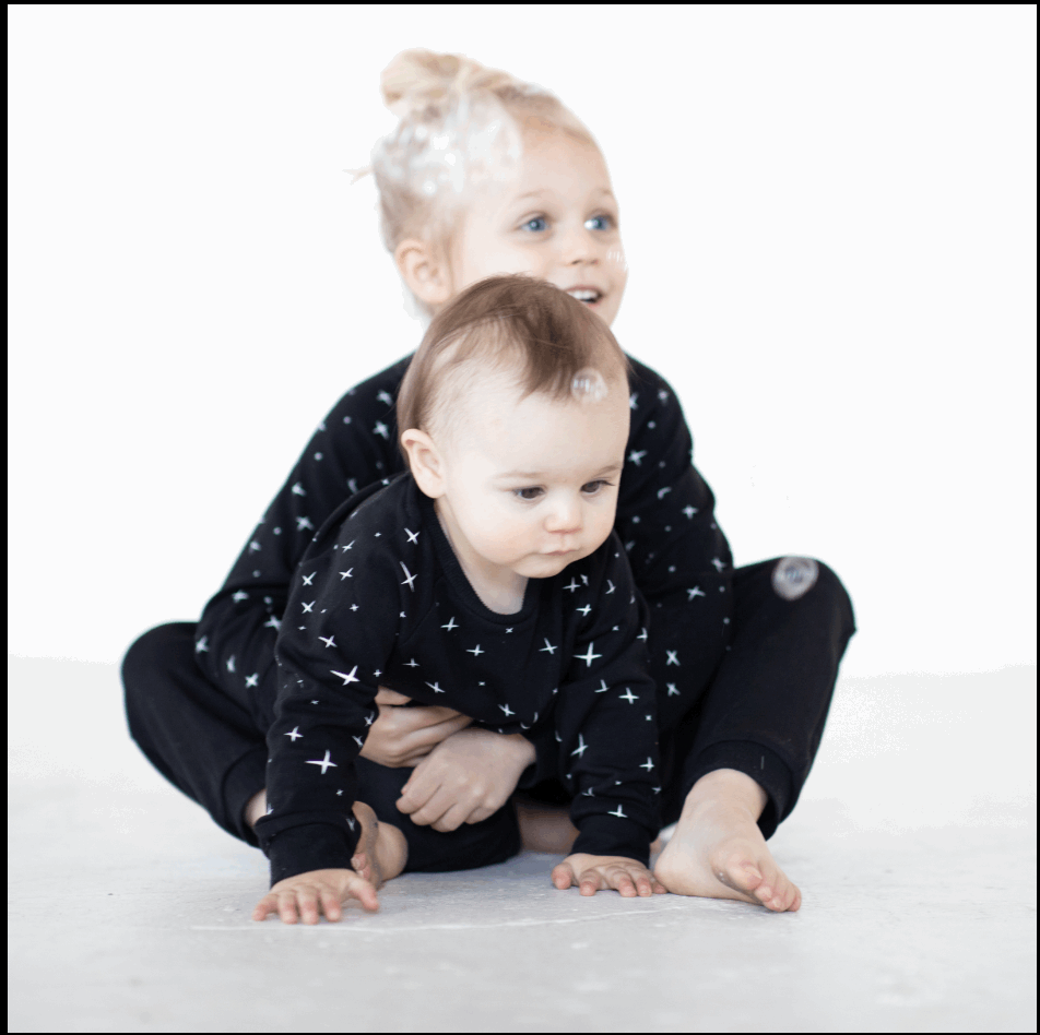 toddler holding baby in peregrine black bamboo sweatshirt and sweatpants
