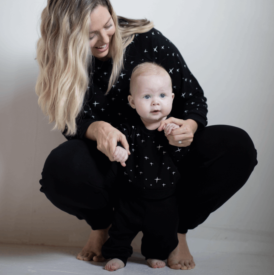 mom holding baby in peregrine black bamboo sweatshirt and sweatpants