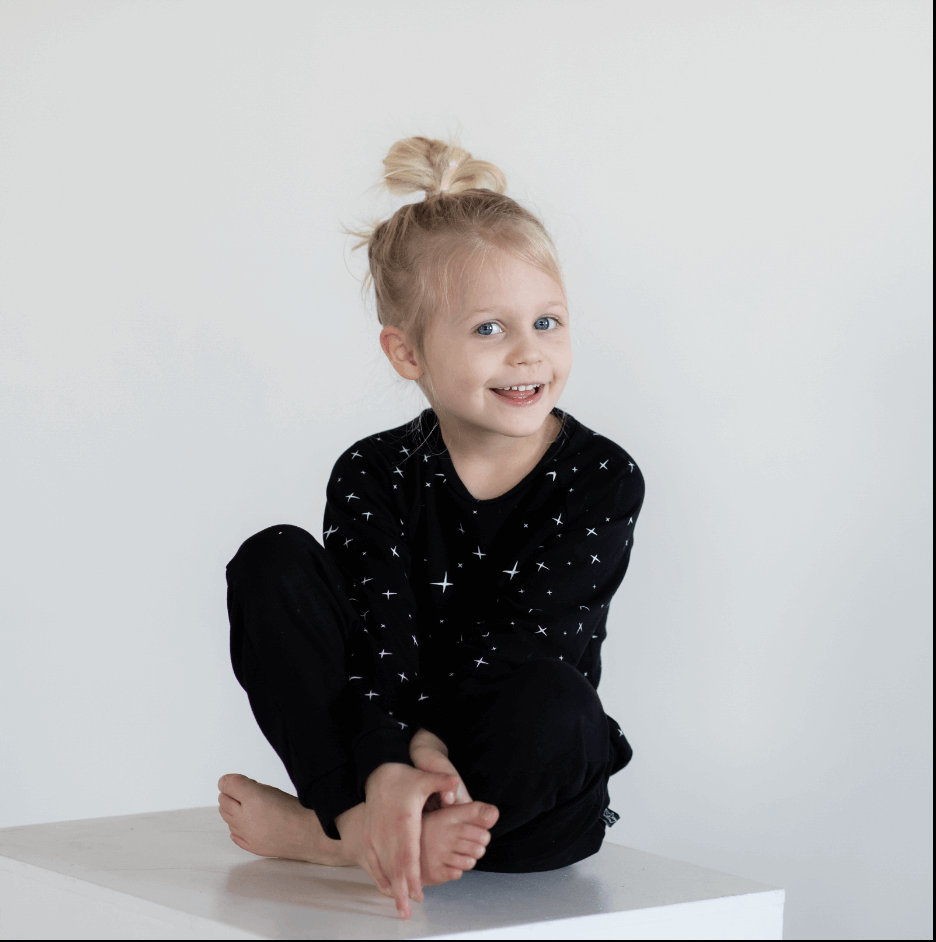 toddler sitting wearing black peregrine sweatshirt and joggers