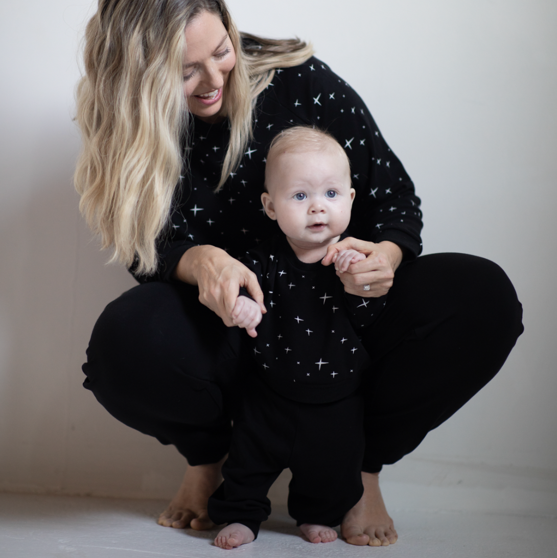 mom holding baby in peregrine black bamboo sweatshirt and sweatpants
