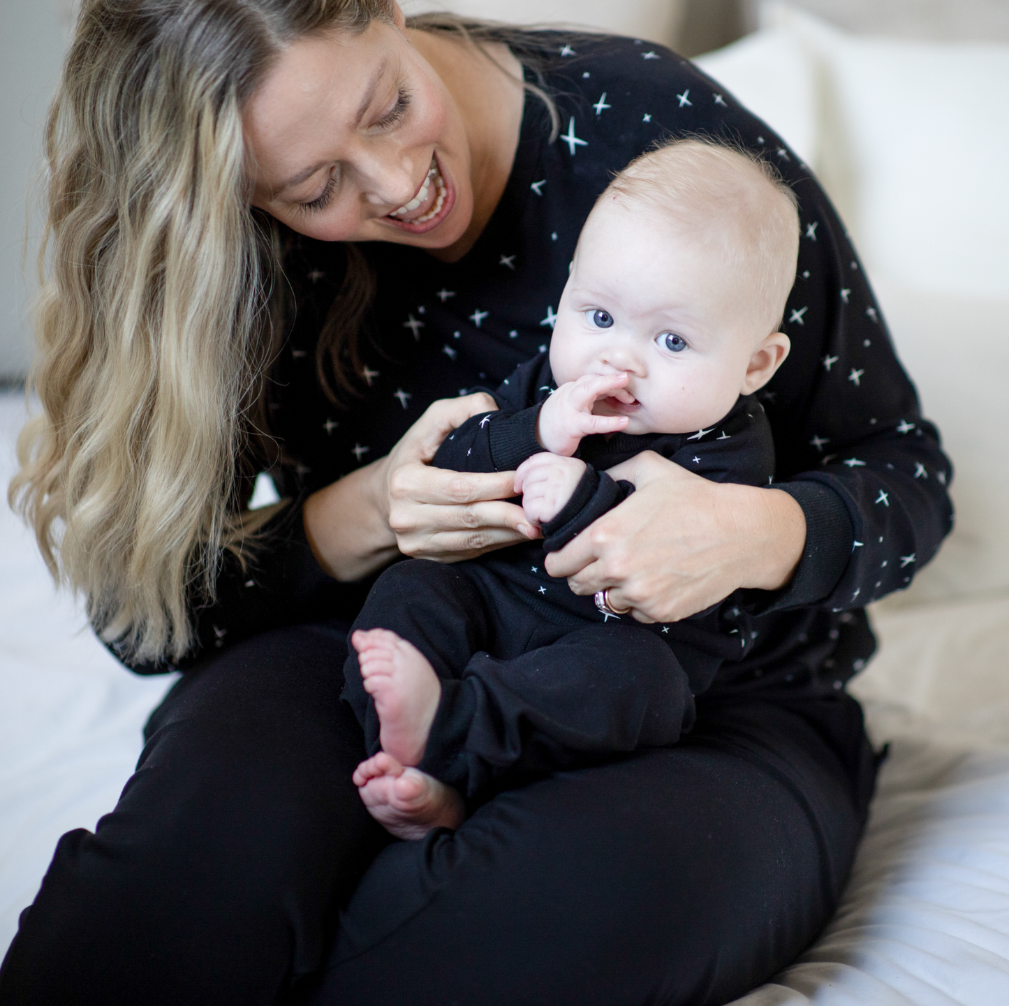 mom holding baby in peregrine black bamboo sweatshirt and sweatpants