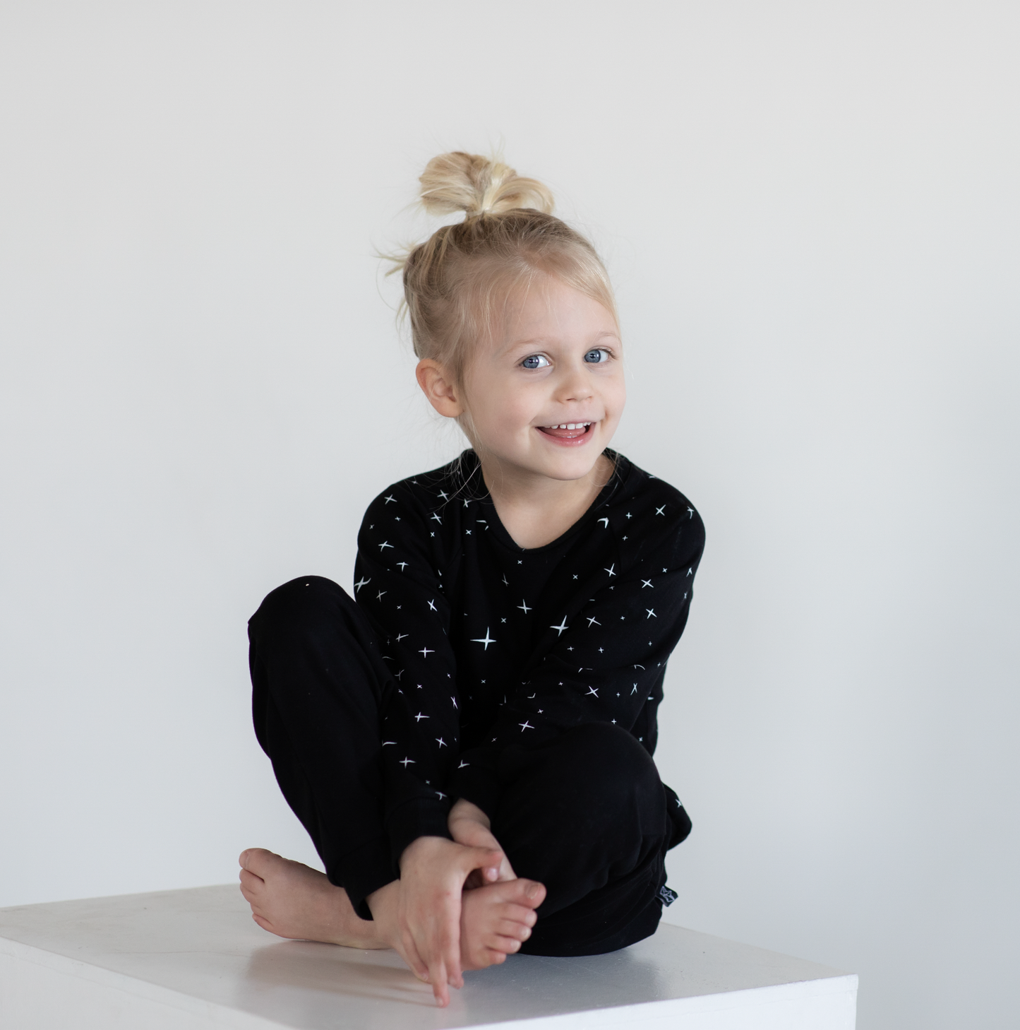toddler sitting wearing black peregrine sweatshirt and joggers