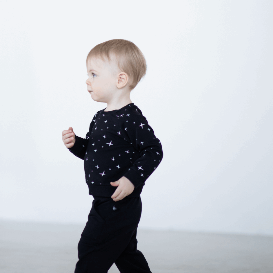 toddler standing wearing black peregrine sweatshirt and joggers